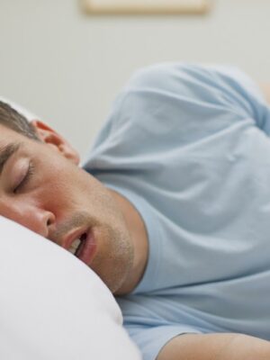 man lying asleep in his bed