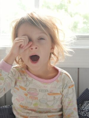 young child yawning in bed