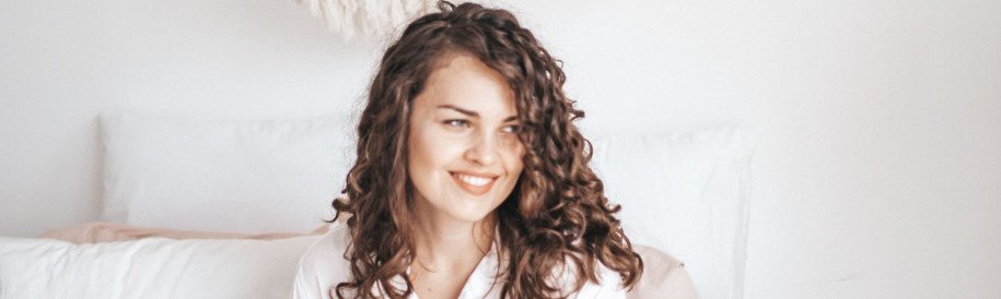 headshot of woman on bed