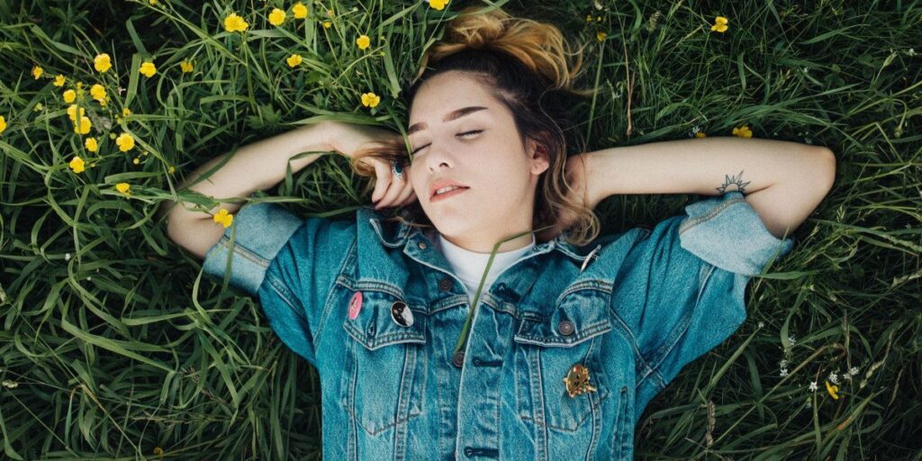 young girl sleeping outdoors in the grass