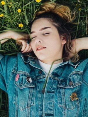 young girl sleeping outdoors in the grass