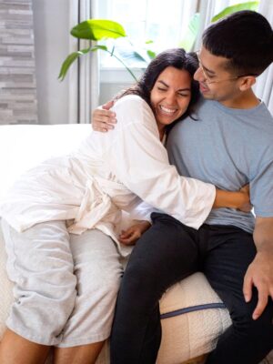 couple warmly embracing on top of a my green mattress hybrid mattress