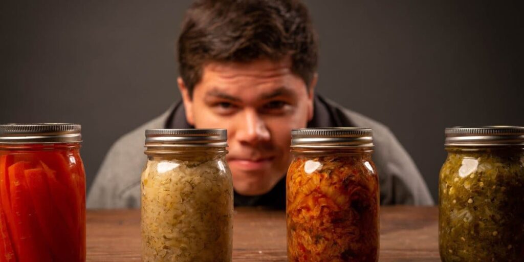 man looking at canning jars on table
