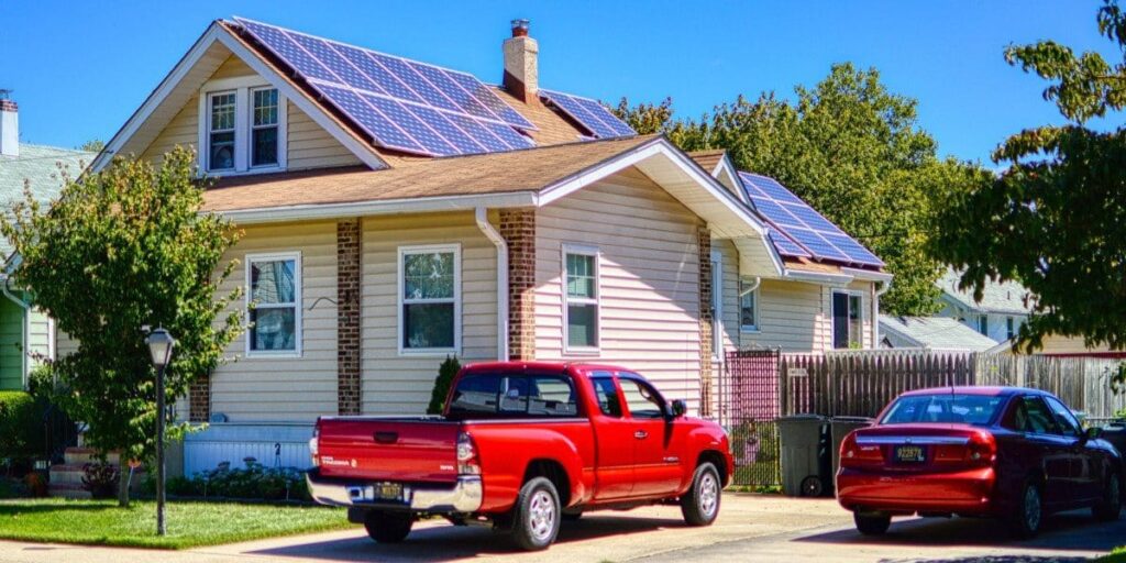 sunny view of home with solar panels on it