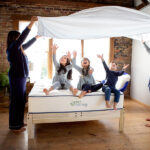 Family enjoying organic cotton sheets made with non-toxic, GOTS-certified fabric