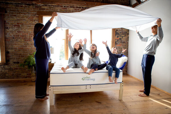 Family enjoying organic cotton sheets made with non-toxic, GOTS-certified fabric