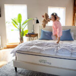 Child jumping on Kiwi organic mattress in bright bedroom