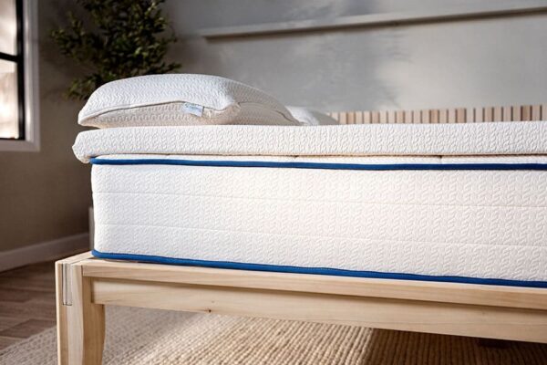 Side profile of organic latex mattress topper on bed showing detail