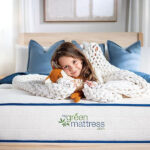 Child laying with stuffed animal on kiwi organic mattress in bright modern bedroom setting