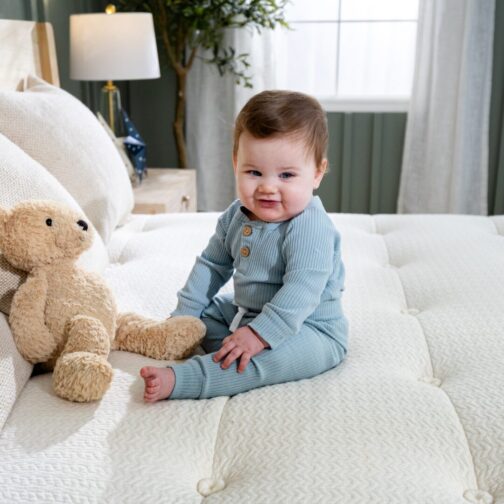 Baby boy on the hand-tufted Kiwi Organic Mattress, demonstrating its craftsmanship and durability.