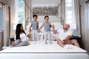 family with kids sitting on bed