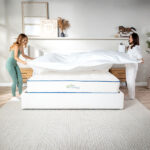 Two women making the bed on a Natural Escape Organic Mattress with a My Green Mattress organic bedding bundle for added comfort