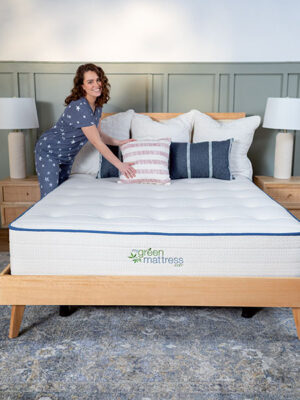 Kiwi Organic Mattress with American flag themed throw pillows and model.