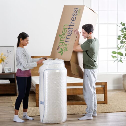 A couple unboxing their Natural Escape organic mattress, highlighting My Green Mattress’s 365-night sleep trial and 20-year warranty.