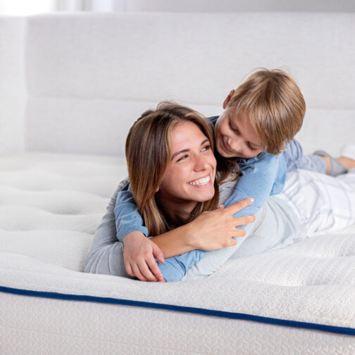 A mom and child smiling and relaxing on the Pure Eco Organic Kids Mattress, highlighting its toxin-free, allergen-free materials creating a healthier sleep environment for the whole family.
