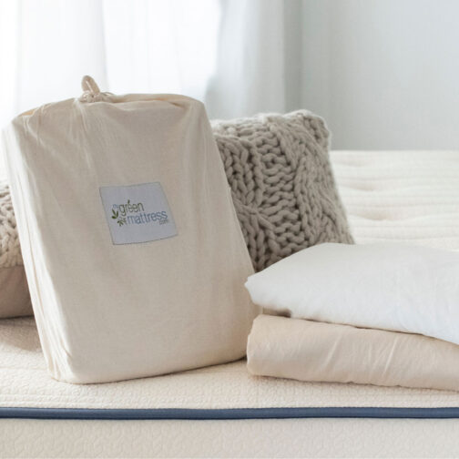 Organic cotton mattress protector and bedding displayed on the Pure Eco Organic Kids Mattress, highlighting recommended care tips for keeping the mattress clean and protected.