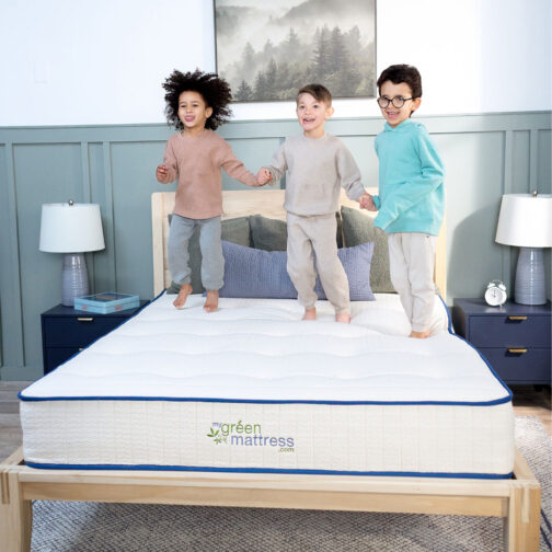 Three children standing and playing on the Pure Eco Organic Kids Mattress, showing its compatibility with the My Green Mattress platform bed for proper support.
