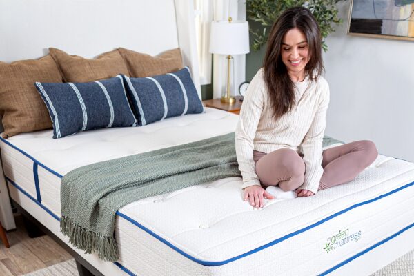 Woman sitting on the Natural Escape organic hybrid mattress by My Green Mattress, handcrafted in Illinois.