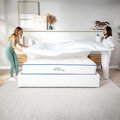 Two woman putting a sheet on top of a Kiwi Organic Mattress