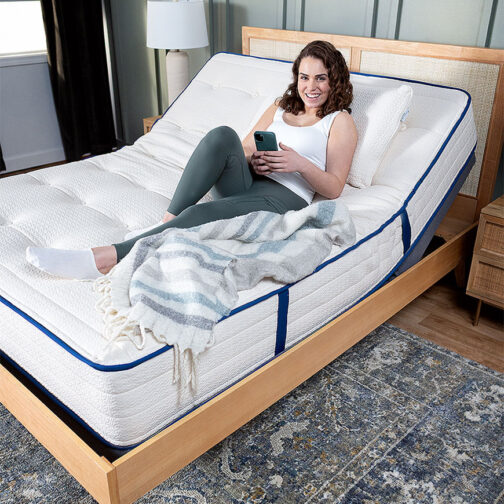 Woman sitting on a Kiwi Organic Mattress that is on an adjustable base